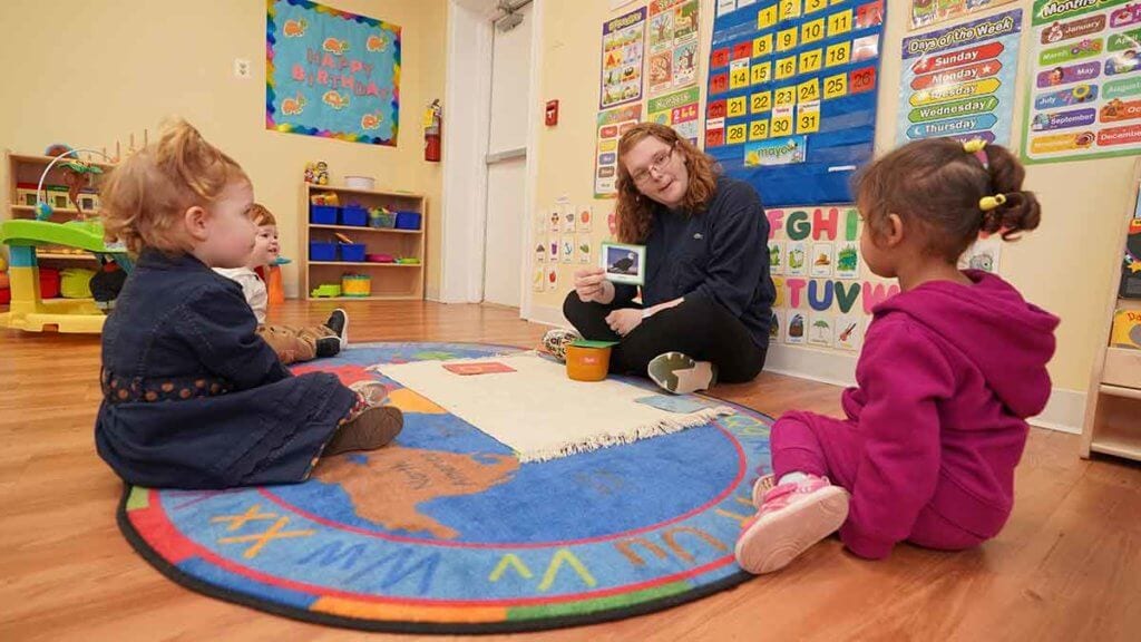 Teacher with children at infant daycare.